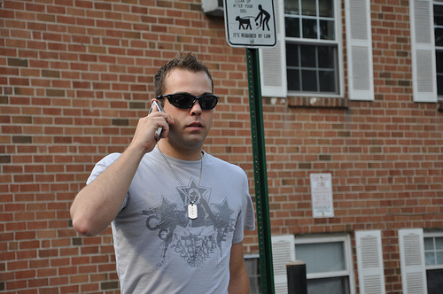 A man walks down New Hope, PA's Main Street and talks on a cellphone.